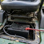Riding mower battery compartment with cables